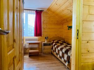a small room with a bed and a table at За горбами in Yaremche