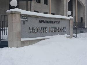 a sign in the snow in front of a building at Apartamentos Monte Hernanz in Riaza
