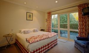 a bedroom with a bed and a large window at Ruapehu Country Lodge in Ohakune