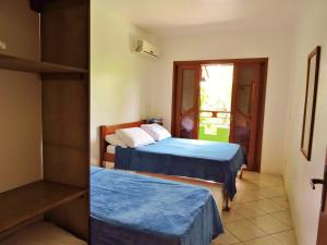1 dormitorio con 2 camas y ventana en Castelo da Ilha en Florianópolis