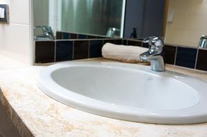 lavabo blanco en el baño con espejo en Hotel Ristorante Morus, en Burago di Molgora