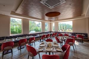 SālāsarAnand Bagh Resort & Spa by Ananta的有桌椅和窗户的餐厅