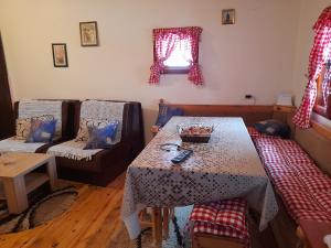 uma sala de estar com uma mesa e um sofá em Holiday Home Ema em Plešin