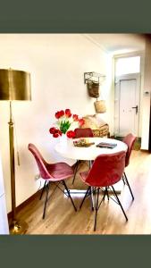 a table with red chairs and a vase of flowers at Foodiejive in Antwerp