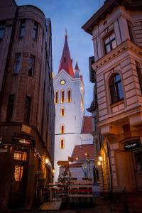 a building with a clock tower in the middle of buildings at Rīgas 20/1 apartaments in Cēsis