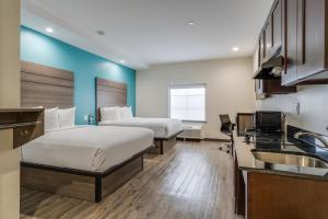 a hotel room with two beds and a sink at Americas Best Value Inn & Suites Katy in Katy