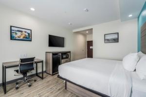a hotel room with a bed and a desk and a computer at Americas Best Value Inn & Suites Katy in Katy
