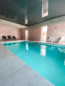 a swimming pool with blue water in a building at La Park Aparthotel in Kudowa-Zdrój