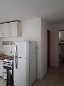a kitchen with a white refrigerator and a stove at Dptos.ECONOMICOS in Necochea