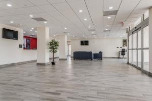 a large office lobby with a potted plant in the middle at Red Lion Inn & Suites Katy in Katy