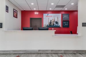 una pared roja en una sala de espera con sillas en Red Lion Inn & Suites Katy, en Katy