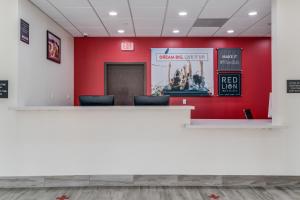 a red wall in a waiting room with chairs at Red Lion Inn & Suites Katy in Katy