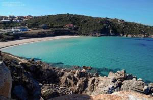 vistas a una playa con agua azul y rocas en La Sartia Apartment, en Porto Pozzo