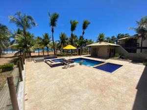a resort with a swimming pool and palm trees at Casa Tropical pé na areia in Salvador