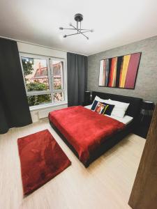 a bedroom with a large bed with a red blanket at AH Mlynská Bašta II Free Parking in Košice