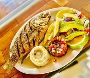 ein Teller mit Fisch und Gemüse auf dem Tisch in der Unterkunft Casa de Descanso las Camelinas Para 21 personas in Playa Azul