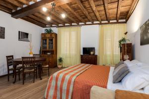 a bedroom with a bed and a dining room with a table at Vicolo Antico Apartment in Rome