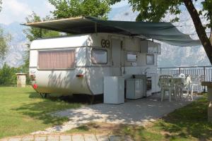 a white trailer with a tent on top of it at Camping Alpino - Nature Village in Malcesine