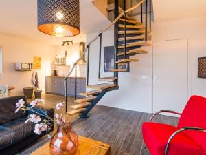 a living room with a spiral staircase and red chairs at Zoutelandseweg 2, Biggekerke in Biggekerke