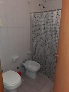 a bathroom with a toilet and a shower curtain at Duplex 7 Lunas in Villa Gesell +41 photos
