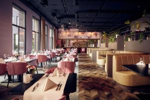 un restaurante con mesas blancas y sillas rosas en Van der Valk Hotel Amersfoort-A1, en Amersfoort