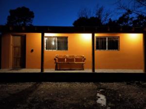 eine Couch, die nachts vor einem Haus sitzt in der Unterkunft Cabaña La Victoriana in Creel
