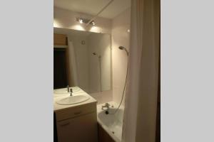 a bathroom with a sink and a mirror and a tub at Appartement studio front de neige, accès direct aux pistes in Isola 2000