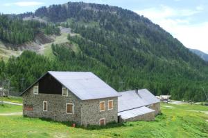ein Steinhaus in einem Feld mit einem Berg in der Unterkunft Appartement studio front de neige, accès direct aux pistes in Isola 2000