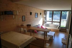 ein Wohnzimmer mit Sofa und Tisch in der Unterkunft Appartement studio front de neige, accès direct aux pistes in Isola 2000