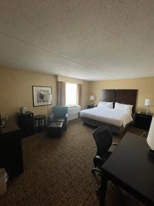 a hotel room with a bed and a chair at Holiday Inn Express Philadelphia Penn's Landing, an IHG Hotel in Philadelphia