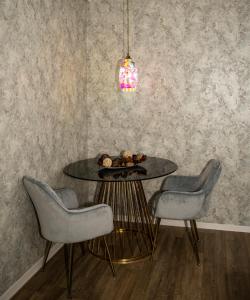 a dining room with a table and two chairs at Raphael Apartment North Bucharest Cosmopolis in Ştefăneştii de Jos