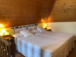 a bedroom with a large bed in a wooden ceiling at Apartamentos y Casas de Aldea La Pornacal in Villar de Vildas