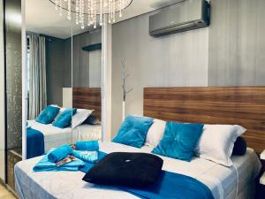 a bedroom with two beds with blue pillows and a mirror at 303 - Rentaqui - Studio Augusta Elegance Pool New in Sao Paulo