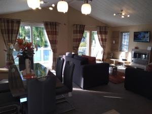 CheswickにあるCastle Lake Lodgeのリビングルーム(ソファ、テーブル、椅子付)