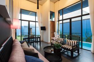 sala de estar con sofá, sillas y ventanas en Wings Phuket Villa by Two Villas HOLIDAY, en Bang Tao Beach