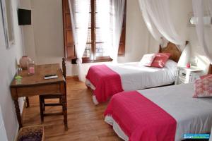 A bed or beds in a room at Hotel Rural Inz-Almaraz