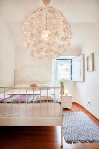 een slaapkamer met een bed en een kroonluchter bij Castle View at Lisbon Heart By TimeCooler in Lissabon