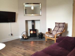 a living room with a couch and a wood stove at Forest of Dean Country Cottage in Mitcheldean