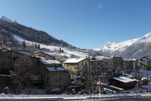 a town in the snow with mountains in the background at Appartamento vicino al centro da Lori in Bormio