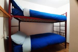 a room with two bunk beds with blue pillows at Appartamento vicino al centro da Lori in Bormio