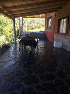 a patio with a table and a bench in a building at Posada El Antiguo Refugio potrero de los funes in Potrero de los Funes
