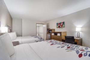 a hotel room with two beds and a desk at Red Roof Inn St George, SC in Saint George