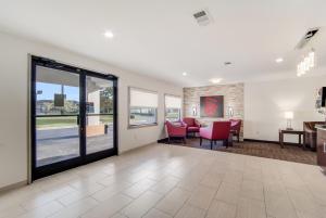 a lobby with a waiting room with red chairs at Red Roof Inn St George, SC in Saint George