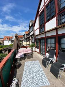 eine Terrasse mit einem Sofa, Stühlen und einem Sonnenschirm in der Unterkunft Altstadt Quartier Hameln in Hameln