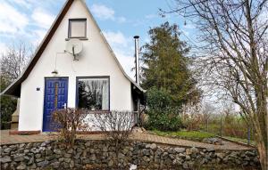 una pequeña casa blanca con una puerta azul en Lovely Home In Wernigerode With Kitchen, en Wernigerode