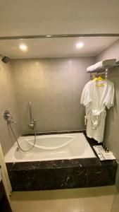 ein Badezimmer mit einer Badewanne und einem Waschbecken in der Unterkunft Gis Select Banjara Hill in Hyderabad