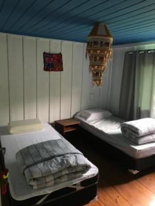 a bedroom with two beds and a chandelier at Casa colonial azul Santuário Bellatrix in Ribeirão Amarelo