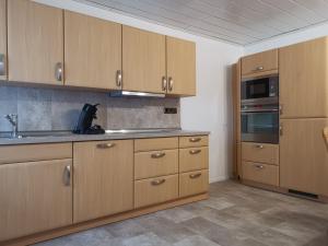 a kitchen with wooden cabinets and a stove top oven at Ihre Ferienwohnung in 67454 Haßloch - Pfalz in Haßloch