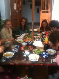 a group of people sitting around a table with food at Hai Dang Homestay in Hoi An