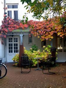 um pátio com uma mesa e cadeiras em frente a uma casa em Altstadt Charme em Augsburg